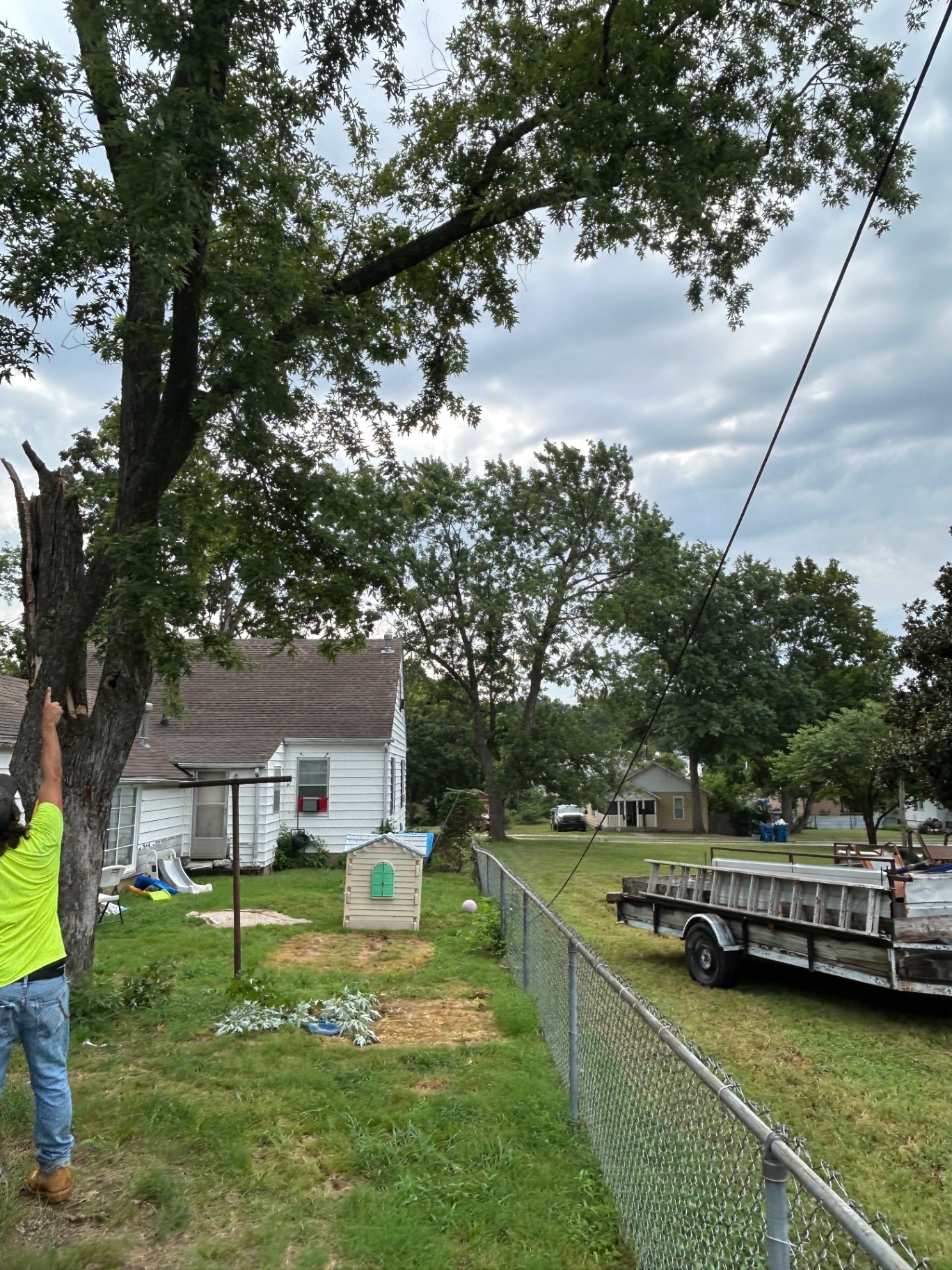 Storm Limb Takedown — Broken limb removal and haul off, trailer staged and the yard left clean.